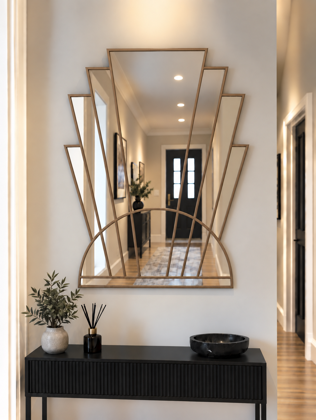 An Art Deco style wall mirror with a silver metal frame, featuring vertical mirror panels and a semi-circular arch base, mounted on a white wall.