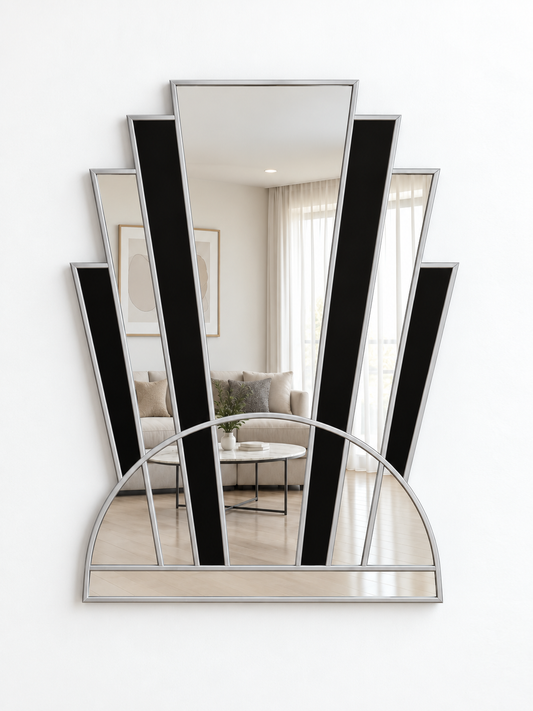 An Art Deco style wall mirror with a silver metal frame, featuring vertical black panels and a semi-circular arch base, mounted on a white wall.