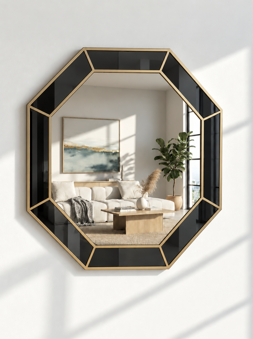 An octagonal wall mirror with a black and gold geometric frame, mounted on a white wall. The mirror reflects a modern living room interior with a sofa, coffee table, and potted plant.