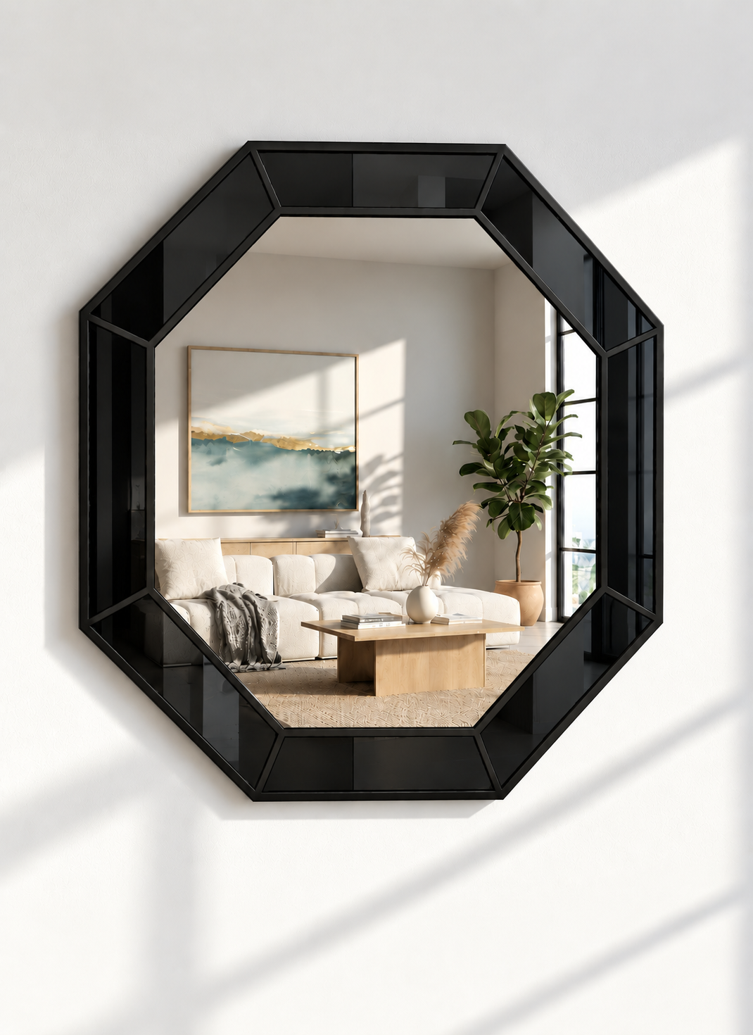 An octagonal black-framed mirror mounted on a white wall, reflecting a modern living room with a sofa, coffee table, and potted plant.