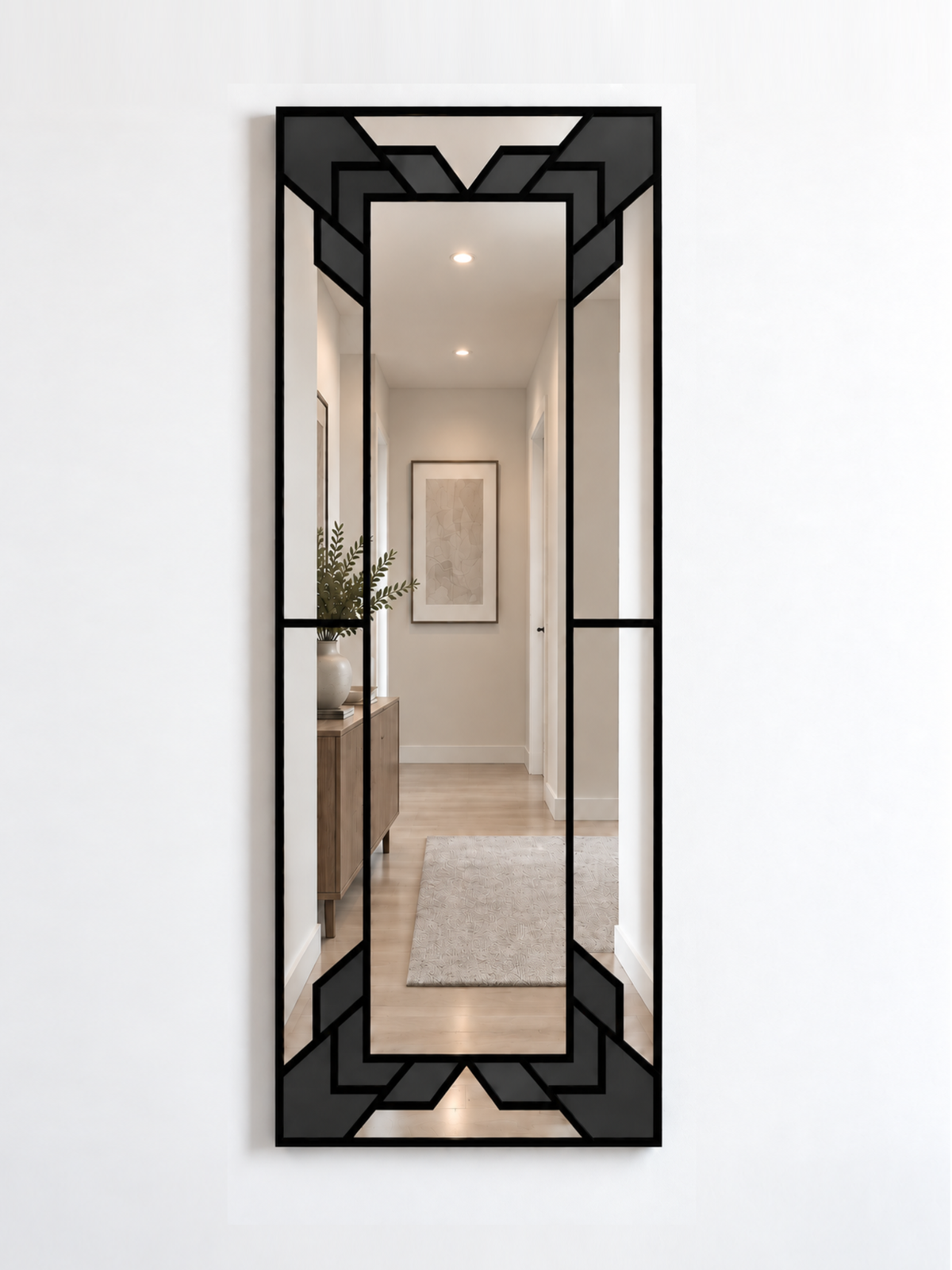 A slim rectangular geometric/art deco wall mirror with a black frame and black sections