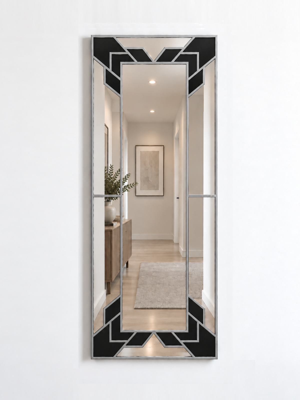 A slim rectangular geometric/art deco wall mirror with a silver frame and black sections