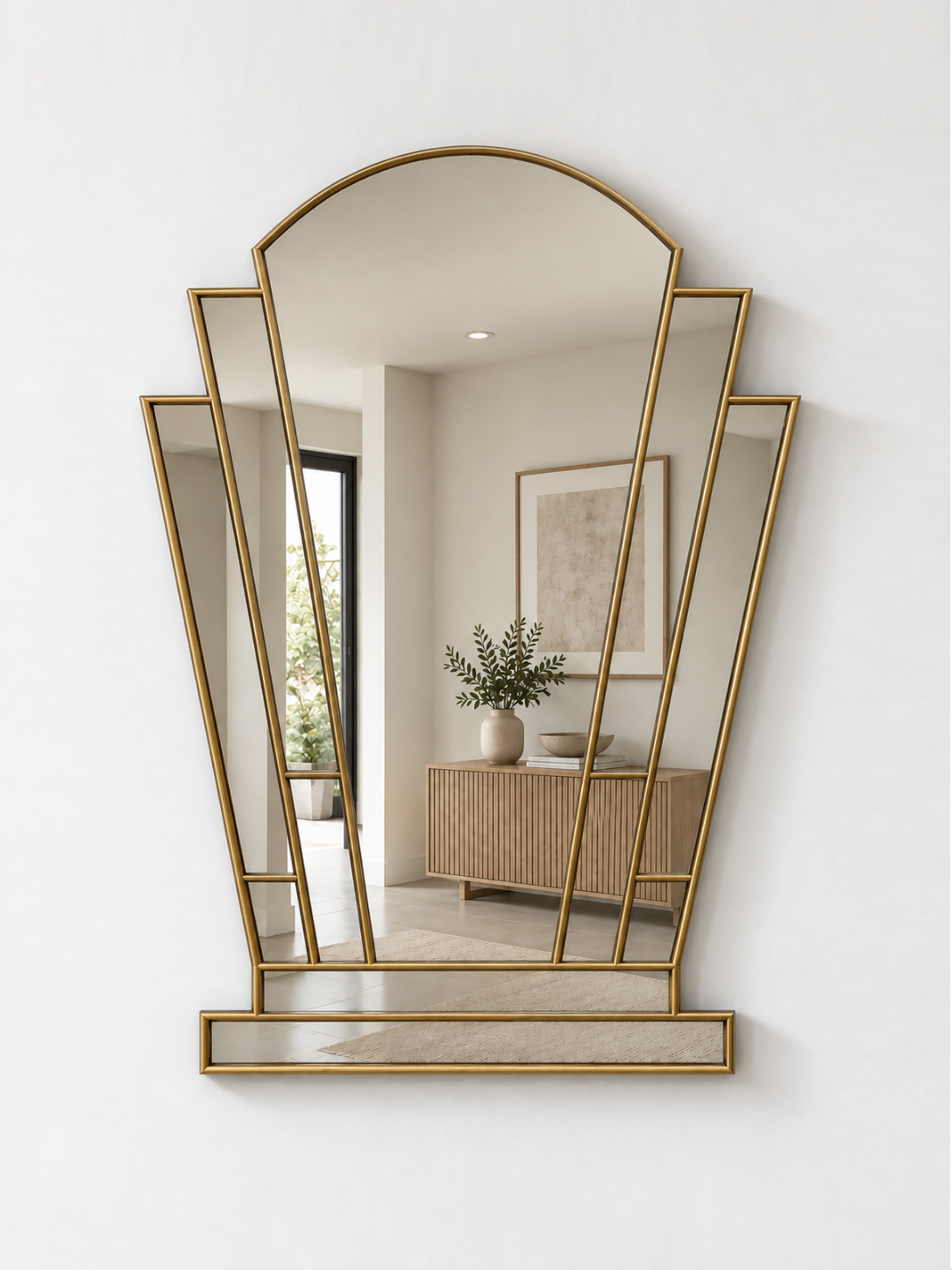 A brass-framed geometric wall mirror with an arched top and multiple angled panels, mounted on a white wall.