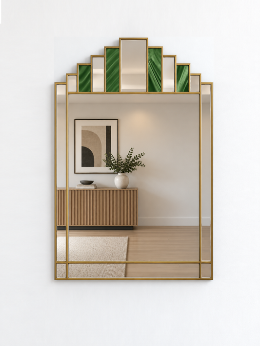 A large art deco style wall mirror with a brass metal frame and green marble inlay accents at the top, shown mounted on a white wall.