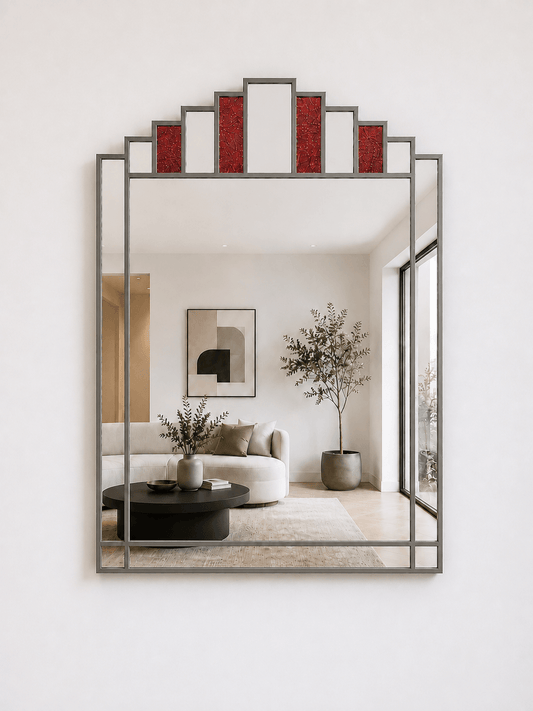A large rectangular wall mirror with a antique metal frame and a decorative stepped top section featuring textured red panels, mounted on a white wall. 