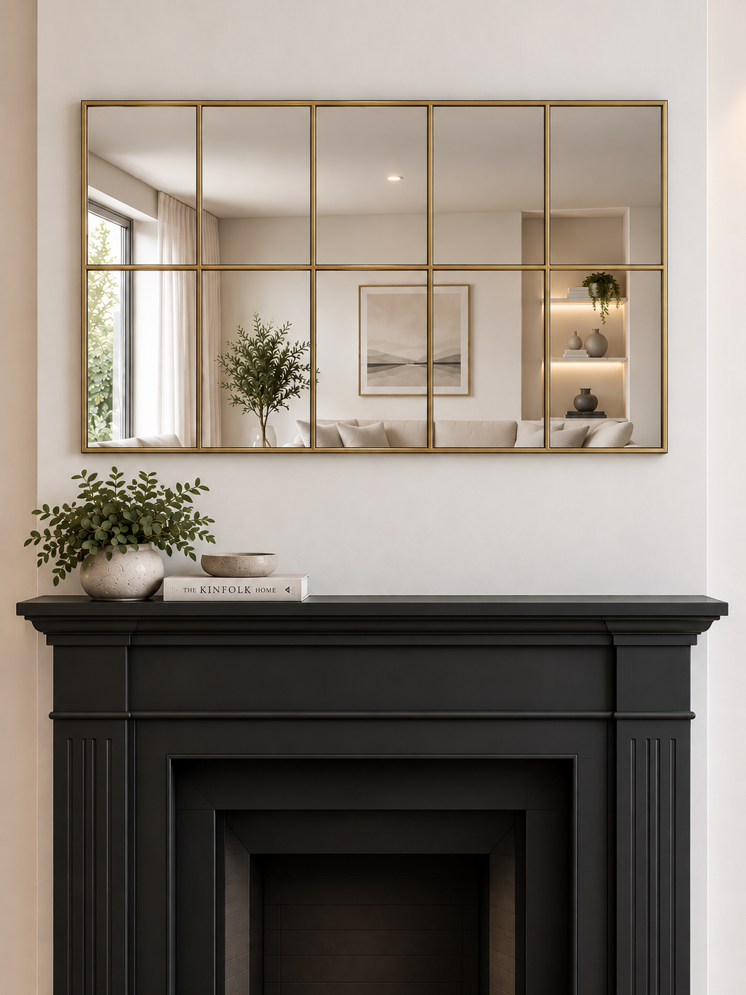 A large rectangular wall mirror with a brass metal grid frame hangs above a black fireplace 