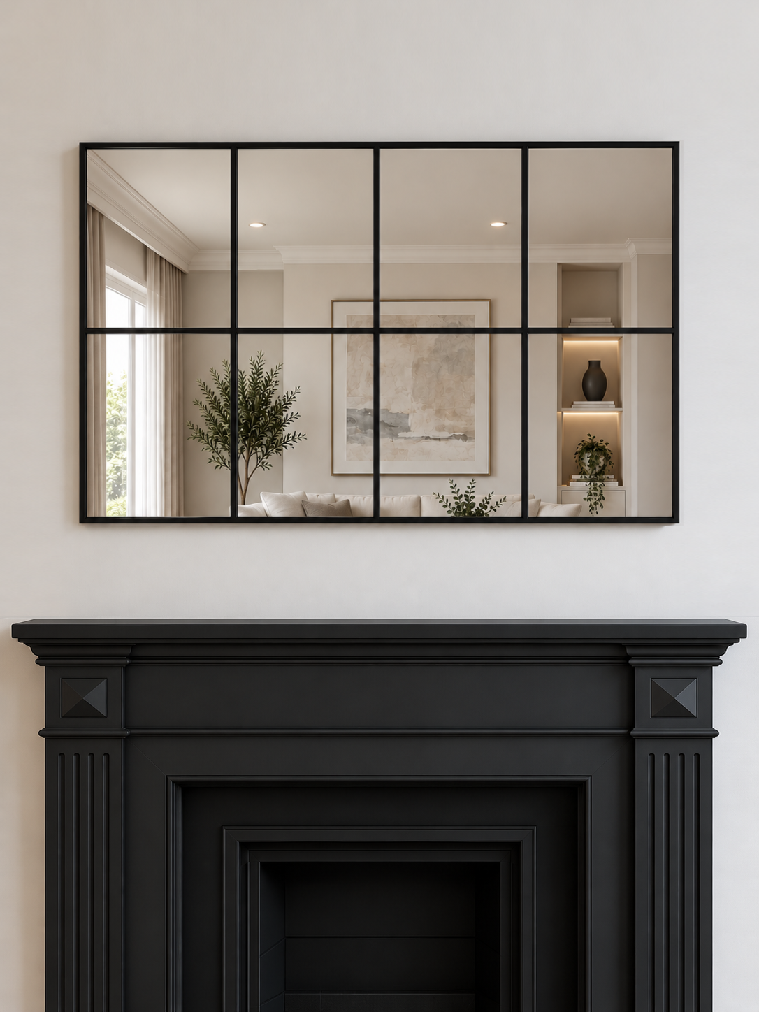 A large rectangular wall mirror with a black metal grid frame hangs above a black fireplace 
