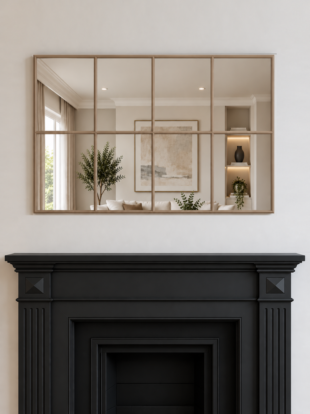 A large rectangular wall mirror with a gold metal grid frame hangs above a black fireplace 