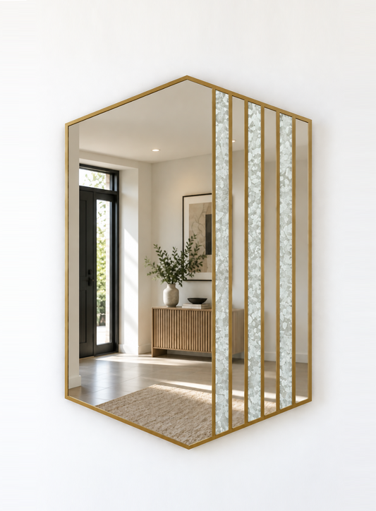 Hexagonal wall mirror with a brass metal frame and vertical textured glass panels, mounted on a white wall.