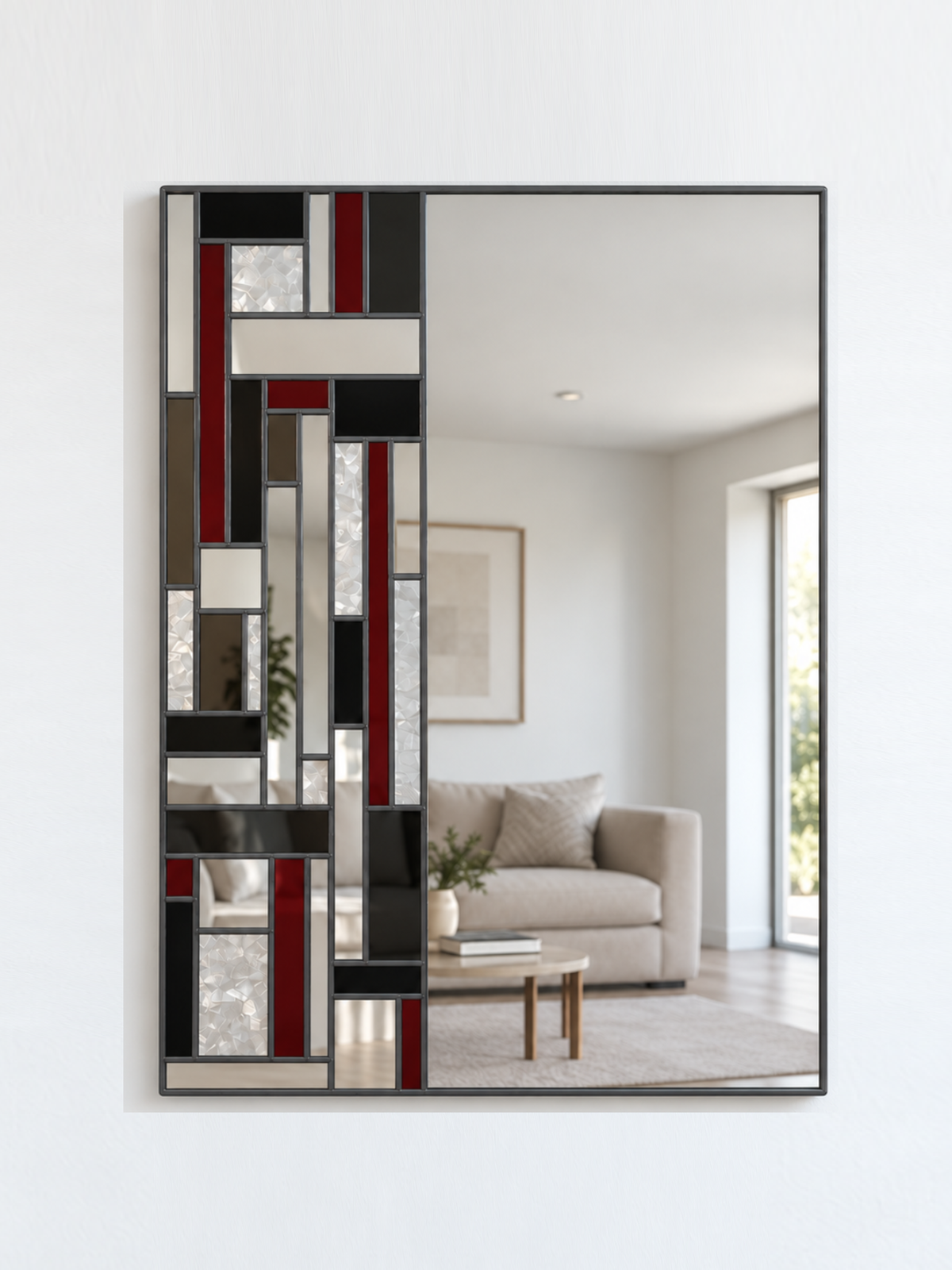 A rectangular wall mirror with an antique frame and an abstract geometric pattern of black, red, grey, and textured glass panels on the left side
