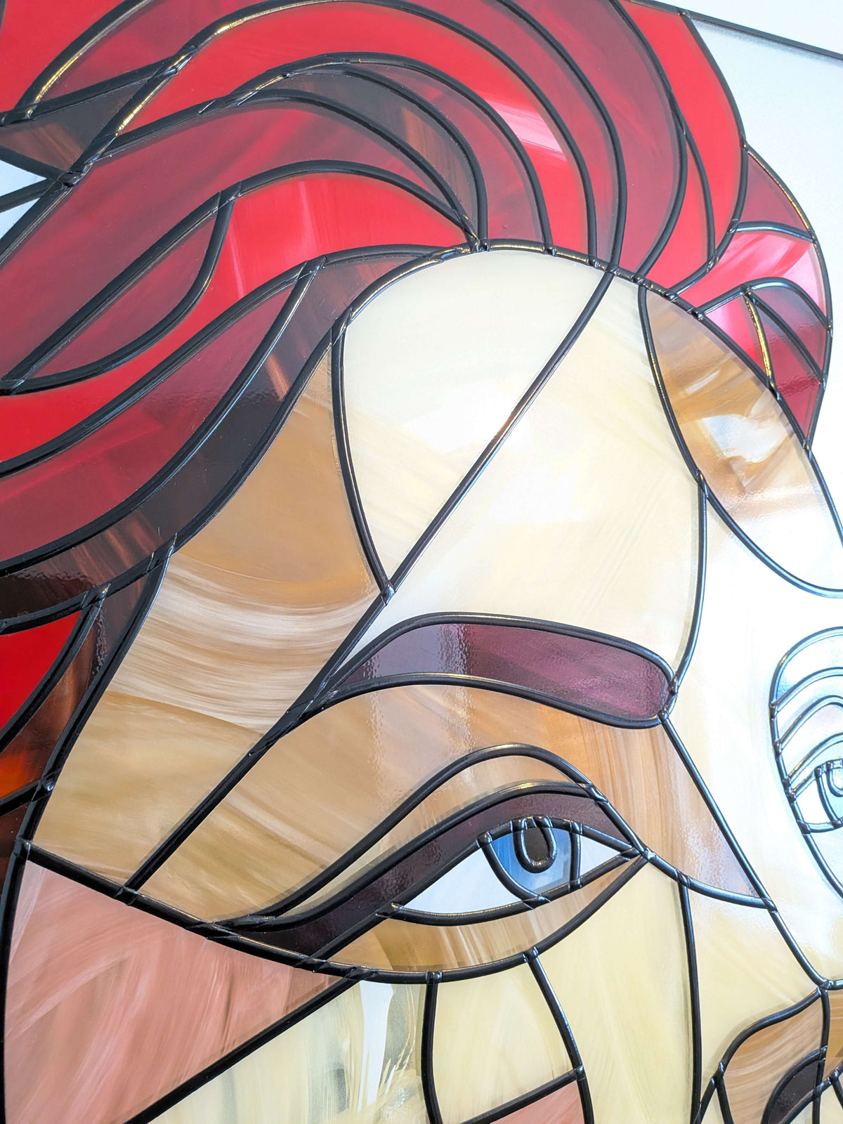 Stained glass panel with a stylized face design