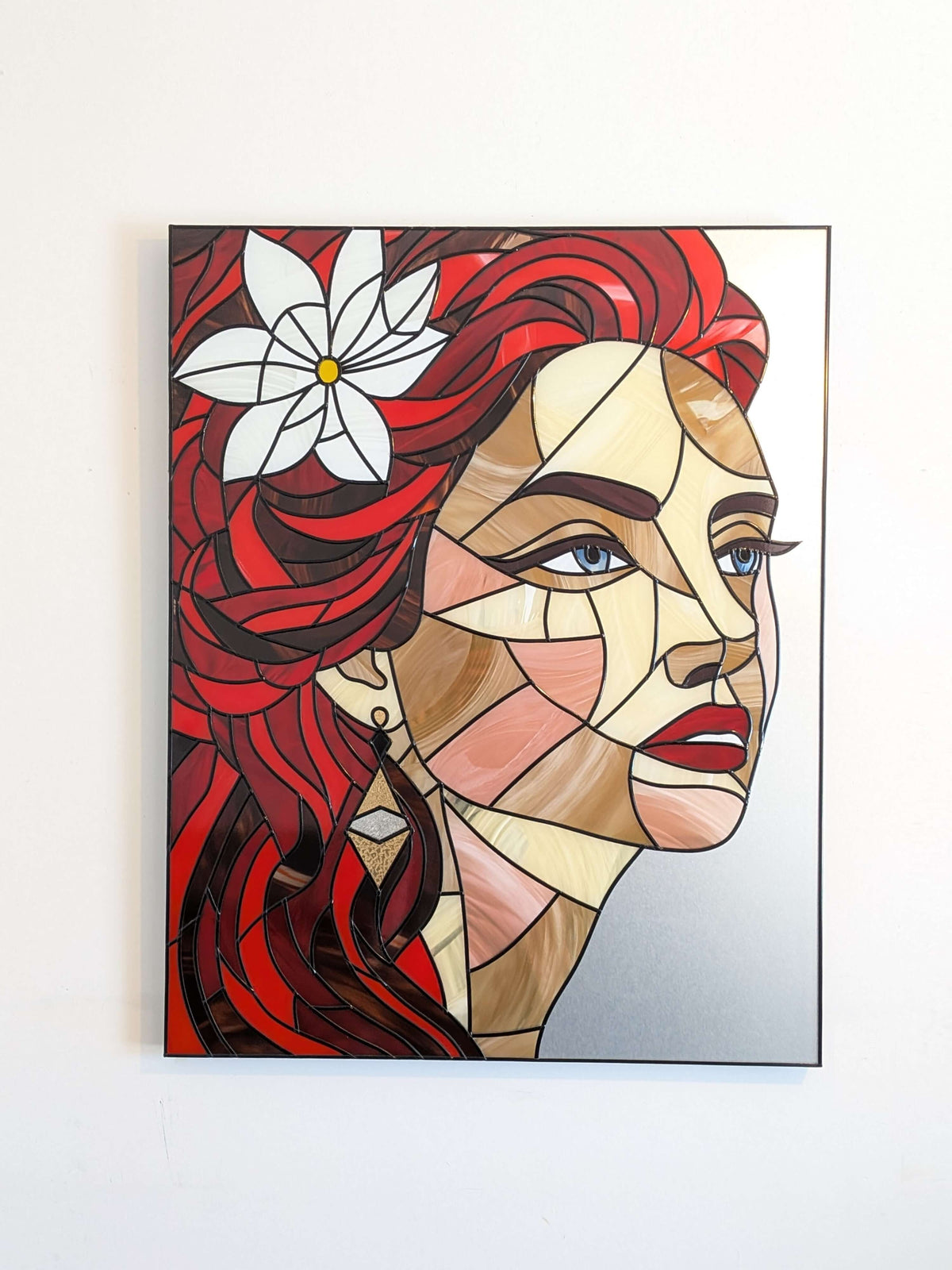Abstract art piece of a woman's face with red hair and a white flower on a white background